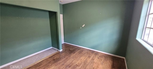 spare room with wood finished floors and baseboards