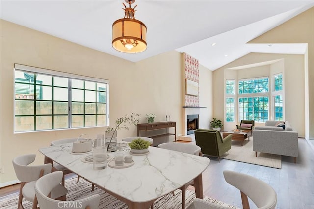 14807 Otsego St, Sherman Oaks, CA 91403 - dining area with wood finished floors, a large fireplace, high vaulted ceiling, and baseboards