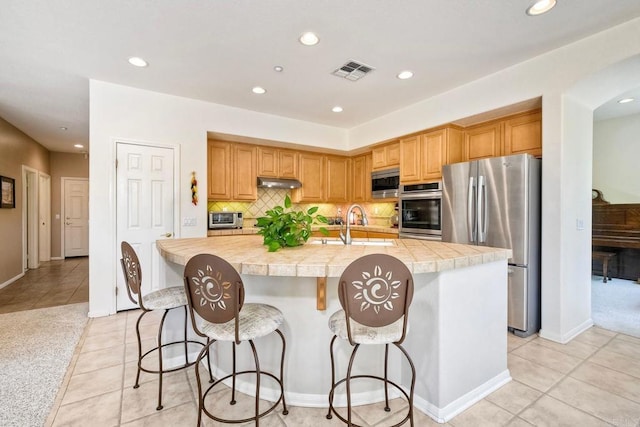 1752 Russet Leaf Ct, El Cajon, CA 92019 - kitchen with stainless steel appliances, under cabinet range hood, light tile patterned floors, recessed lighting, and backsplash