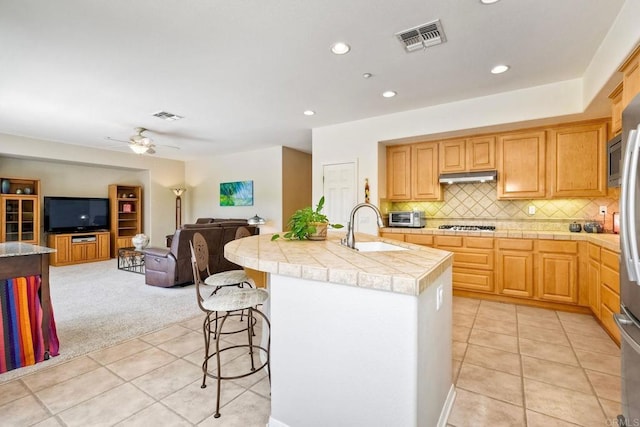 1752 Russet Leaf Ct, El Cajon, CA 92019 - kitchen featuring a sink, light tile patterned floors, under cabinet range hood, an island with sink, and open floor plan