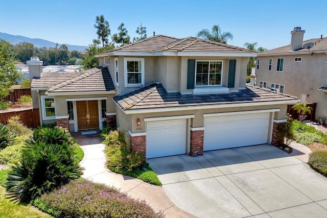 1752 Russet Leaf Ct, El Cajon, CA 92019 - traditional-style home with a garage, concrete driveway, stucco siding, a mountain view, and brick siding