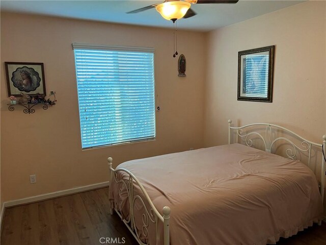 bedroom featuring wood finished floors, baseboards, and ceiling fan