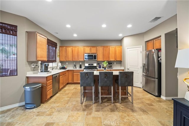 34274 Deergrass Way, Lake Elsinore, CA 92532 - kitchen with appliances with stainless steel finishes, baseboards, stone tile floors, a kitchen island, and recessed lighting