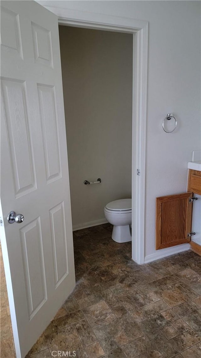 29746 Maxmillian Ave, Murrieta, CA 92563 - bathroom featuring stone finish floors, toilet, baseboards, and vanity