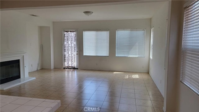 29746 Maxmillian Ave, Murrieta, CA 92563 - unfurnished living room with light tile patterned flooring, a glass covered fireplace, and baseboards