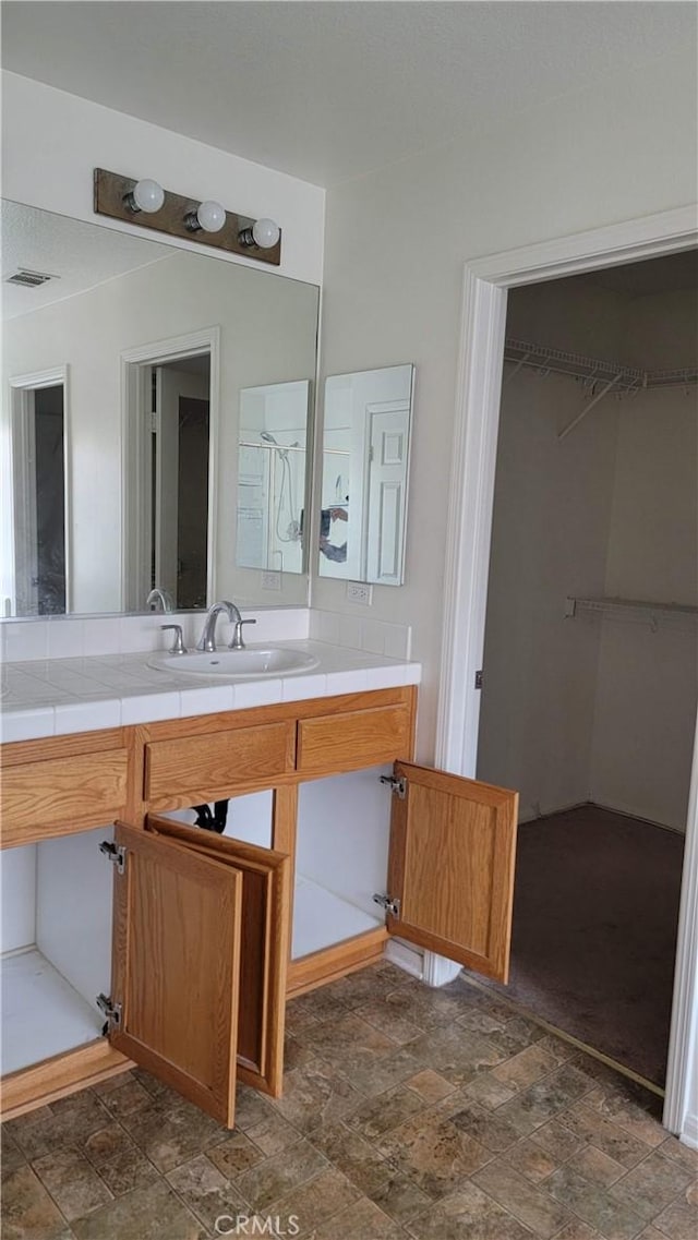 29746 Maxmillian Ave, Murrieta, CA 92563 - bathroom featuring stone finish floors, vanity, and a spacious closet
