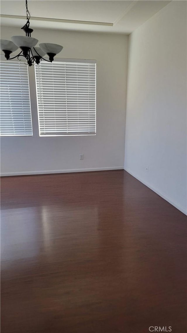 29746 Maxmillian Ave, Murrieta, CA 92563 - spare room with dark wood finished floors, baseboards, and a chandelier