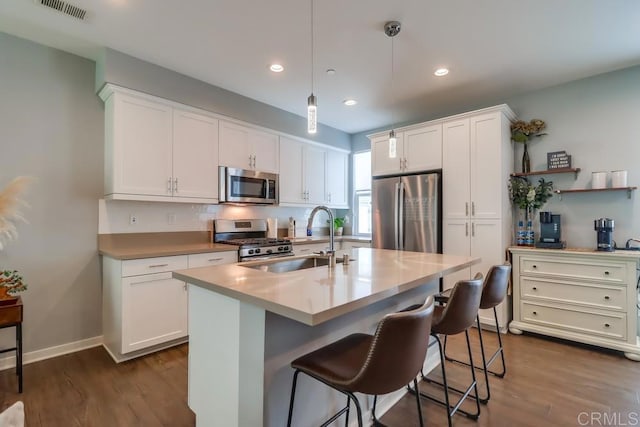 2140 Stellar Way Unit 4, Chula Vista, CA 91915 - kitchen with appliances with stainless steel finishes, white cabinetry, a breakfast bar area, dark wood-style floors, and recessed lighting