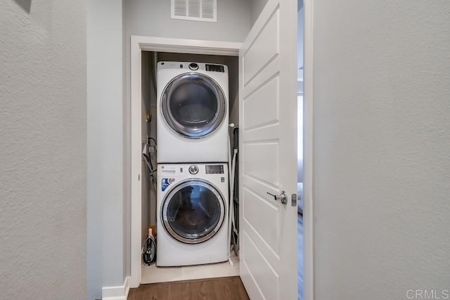2140 Stellar Way Unit 4, Chula Vista, CA 91915 - laundry area with stacked washer / drying machine, a textured wall, and wood finished floors