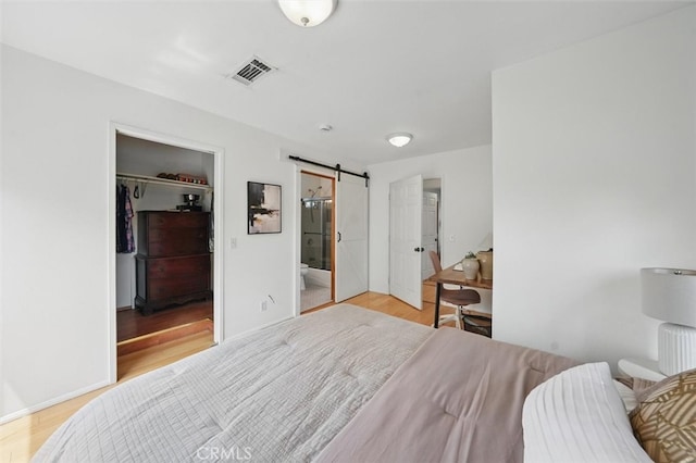 850 N Naomi St, Burbank, CA 91505 - bedroom featuring a barn door, a spacious closet, wood finished floors, a closet, and connected bathroom