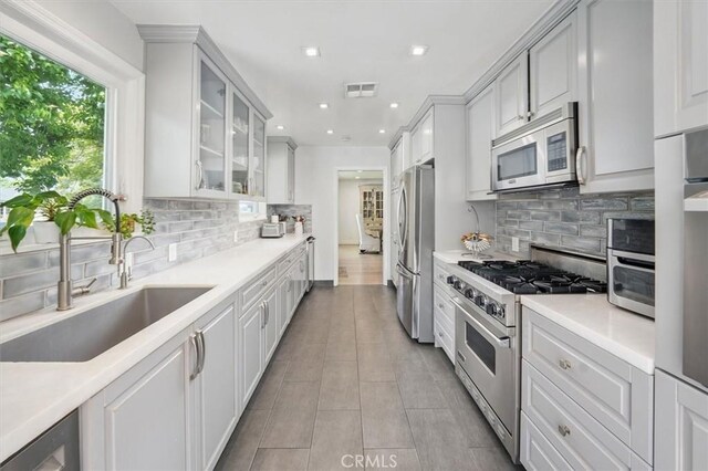 850 N Naomi St, Burbank, CA 91505 - kitchen featuring stainless steel appliances, recessed lighting, light countertops, tasteful backsplash, and glass insert cabinets
