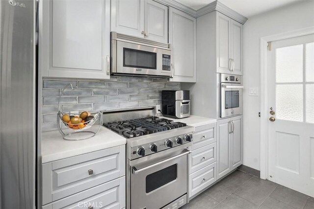 850 N Naomi St, Burbank, CA 91505 - kitchen with appliances with stainless steel finishes, backsplash, healthy amount of natural light, and light tile patterned floors