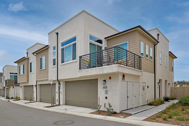 view of front of home with a balcony, stucco siding, and an attached garage