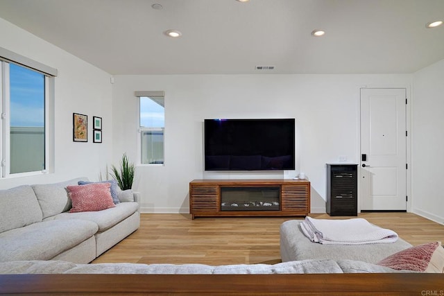 living area featuring wood finished floors, baseboards, and recessed lighting