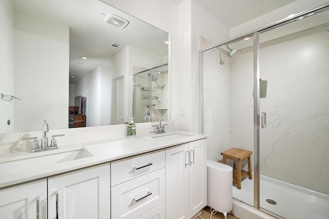 bathroom featuring a stall shower, double vanity, and recessed lighting