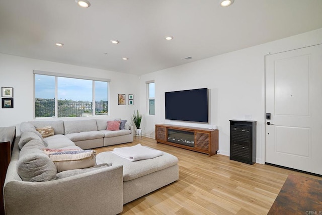 living area featuring light wood-type flooring, recessed lighting, and baseboards