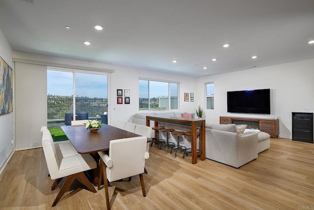 dining space with light wood-style flooring, healthy amount of natural light, and recessed lighting