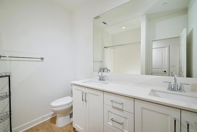 bathroom with wood finished floors, toilet, baseboards, double vanity, and a shower with curtain