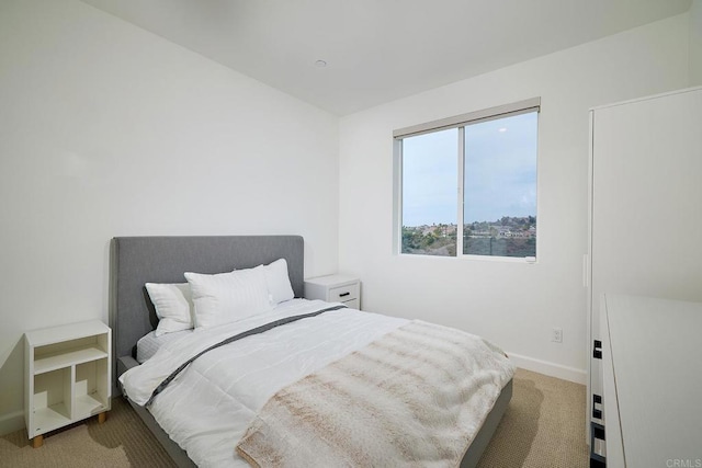 bedroom with light carpet and baseboards