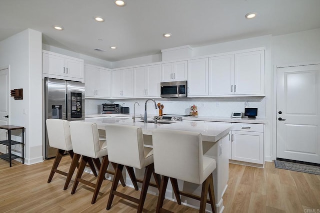 801 Mateo St Unit 2, Chula Vista, CA 91911 - kitchen with stainless steel appliances, recessed lighting, a kitchen breakfast bar, a center island with sink, and light wood finished floors