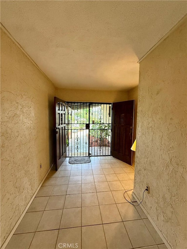 14120 Dillerdale St, La Puente, CA 91746 - unfurnished room with a textured wall, a textured ceiling, baseboards, and light tile patterned floors