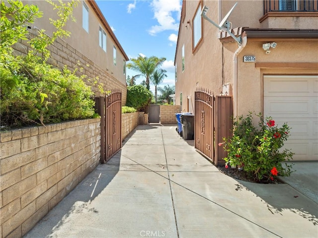 30375 June Rose Ct, Castaic, CA 91384 - view of side of property featuring a gate, stucco siding, and a garage
