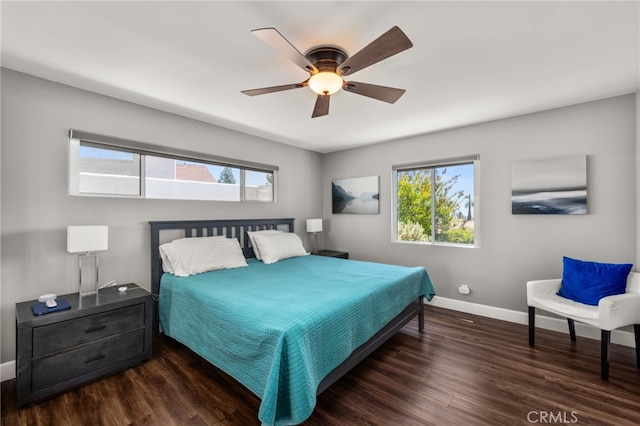 bedroom with multiple windows, wood finished floors, and baseboards