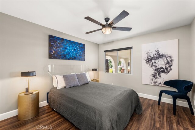 bedroom featuring baseboards, wood finished floors, and a ceiling fan