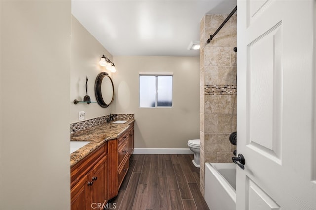 full bath featuring wood tiled floors, baseboards, double vanity, toilet, and tub / shower combination