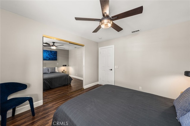 bedroom with wood finished floors, baseboards, a ceiling fan, and a closet