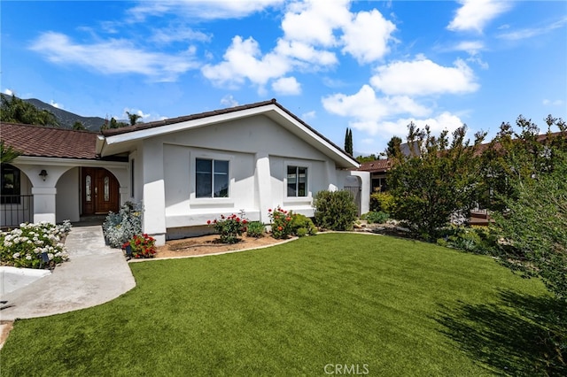 ranch-style home with stucco siding and a front yard