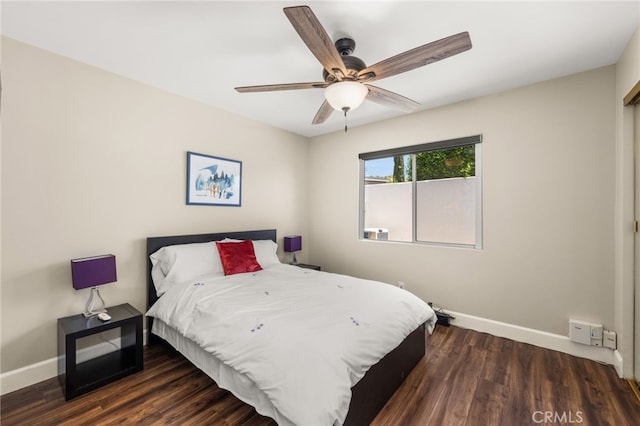 bedroom featuring baseboards, wood finished floors, and a ceiling fan