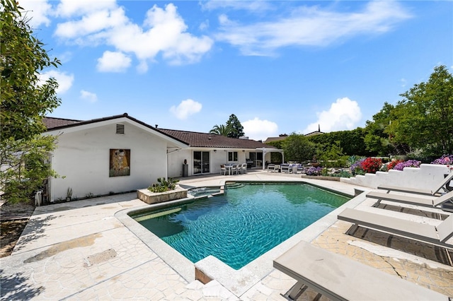 view of swimming pool with a patio area and a pool with connected hot tub