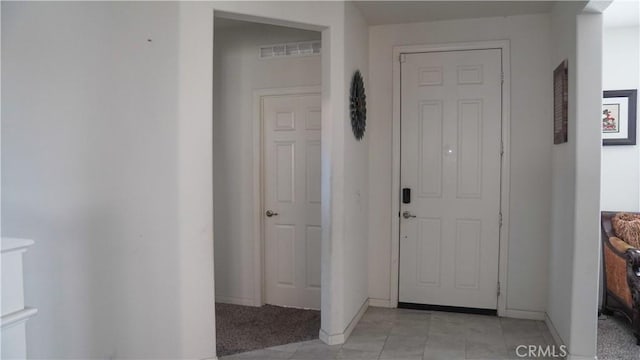 foyer entrance with baseboards and light tile patterned floors