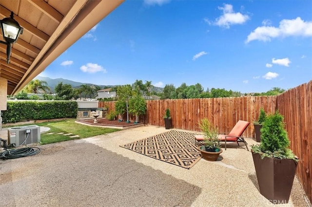22523 White Sage St, Corona, CA 92883 - view of patio / terrace featuring central AC unit, a mountain view, and a fenced backyard