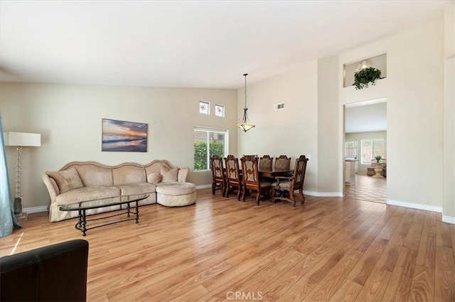 22523 White Sage St, Corona, CA 92883 - living room with healthy amount of natural light, light wood-style flooring, high vaulted ceiling, and baseboards