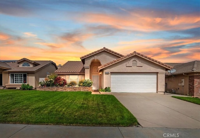 22523 White Sage St, Corona, CA 92883 - mediterranean / spanish-style home with an attached garage, concrete driveway, a yard, and stucco siding