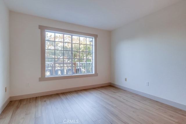 spare room featuring wood finished floors and baseboards