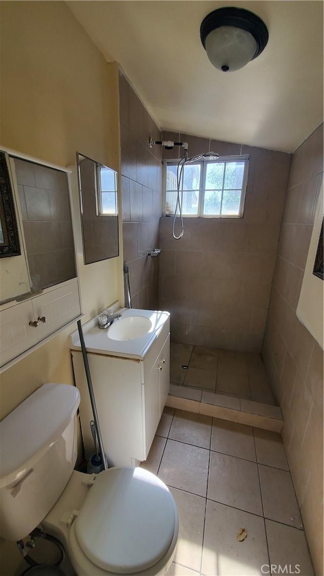 44709 6th St E, Lancaster, CA 93535 - bathroom with tiled shower, toilet, vanity, tile patterned flooring, and tile walls