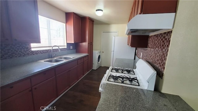 44709 6th St E, Lancaster, CA 93535 - kitchen with a sink, washer and dryer, white appliances, under cabinet range hood, and decorative backsplash