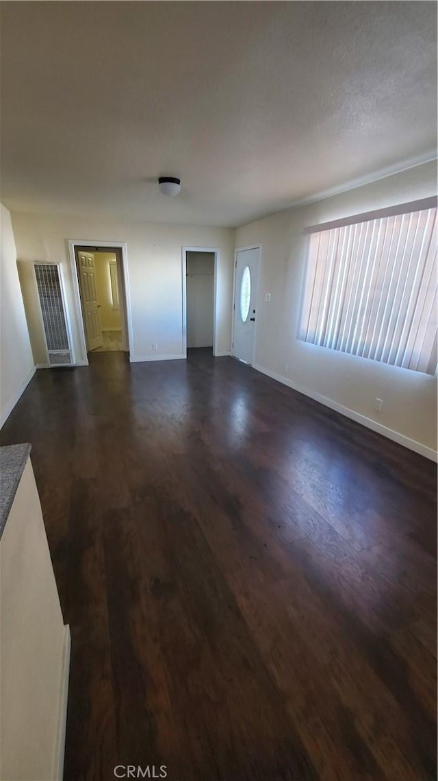 44709 6th St E, Lancaster, CA 93535 - unfurnished living room featuring baseboards and dark wood-style floors
