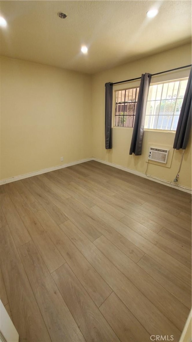 44709 6th St E, Lancaster, CA 93535 - empty room featuring a wall unit AC, wood finished floors, recessed lighting, baseboards, and a textured ceiling