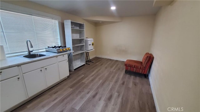 44709 6th St E, Lancaster, CA 93535 - kitchen with a sink, light wood finished floors, white cabinets, open shelves, and baseboards