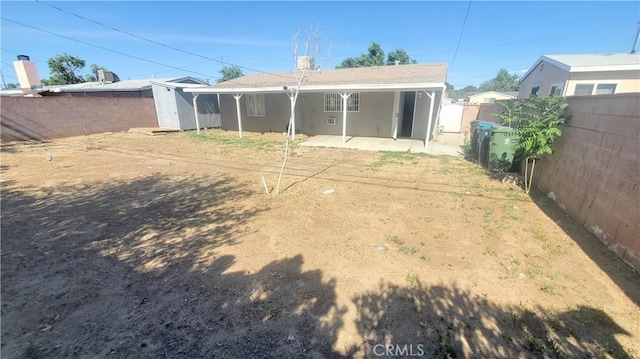 44709 6th St E, Lancaster, CA 93535 - back of property with a fenced backyard, a patio area, a storage unit, stucco siding, and an outbuilding