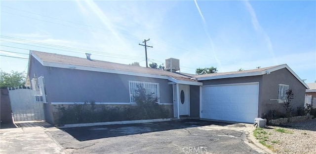 44709 6th St E, Lancaster, CA 93535 - ranch-style house featuring stucco siding, an attached garage, driveway, and cooling unit