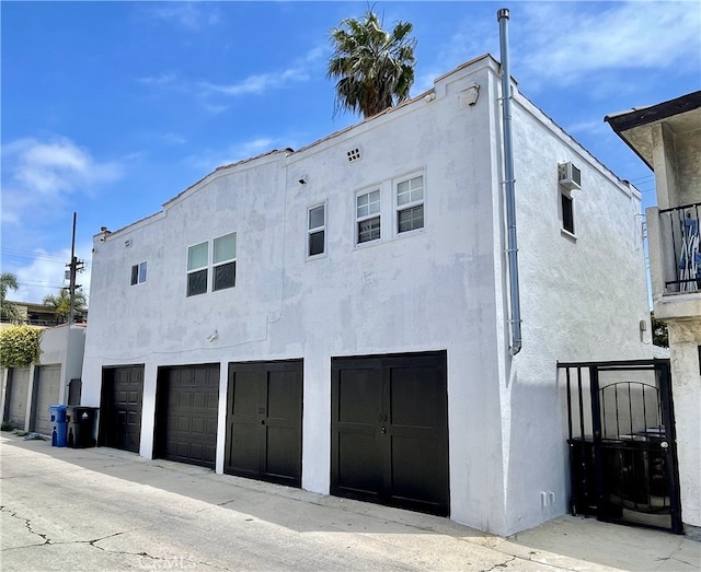 rear view of house featuring a garage and stucco siding