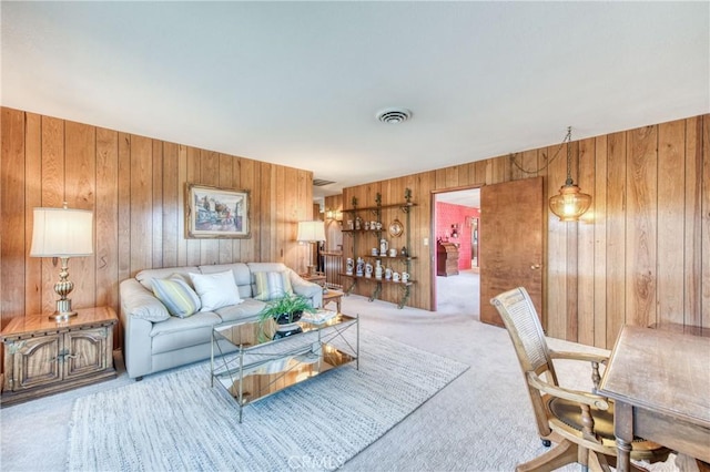 carpeted living room with wooden walls