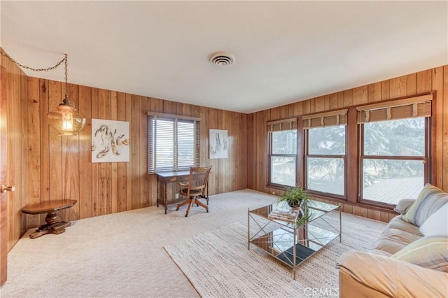 living room featuring carpet and wood walls