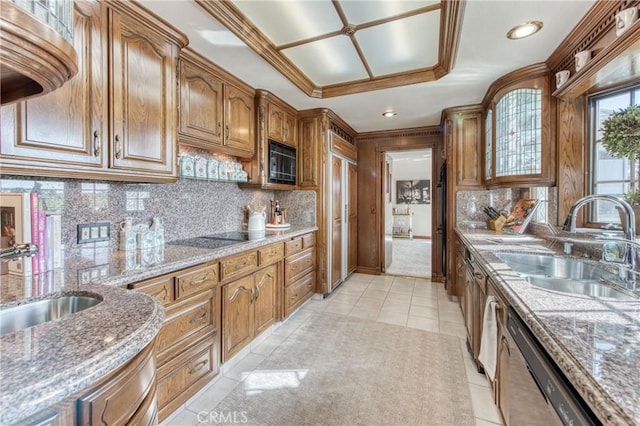 kitchen with black appliances, a sink, backsplash, brown cabinetry, and crown molding