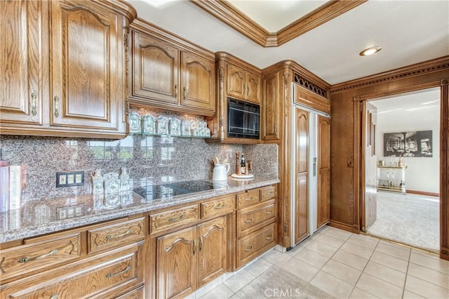 kitchen with black appliances, ornamental molding, brown cabinetry, light tile patterned floors, and backsplash
